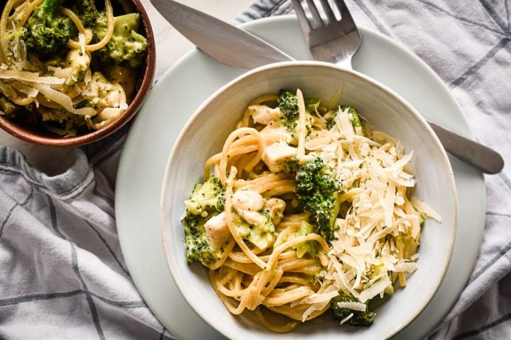 Creamy chicken and broccoli pasta in a bowl with Parmesan cheese. 