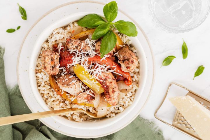 Red pepper chicken breast with sliced peppers, Parmesan cheese, and basil over rice.