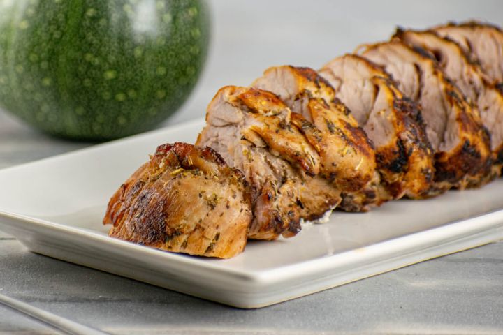 Grilled Mediterranean Pork Tenderloin with a spice rub on a white plate.