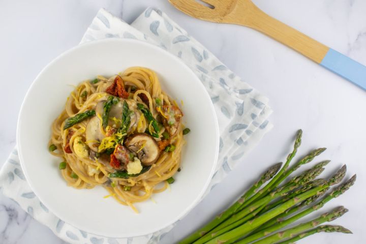 Vegetable alfredo with asparagus, mushrooms, and tomatoes in a creamy alfredo sauce.