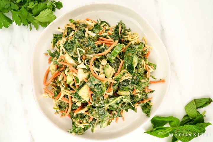 Asian slaw with kale, apples, and carrots with fresh basil and mint on the side.
