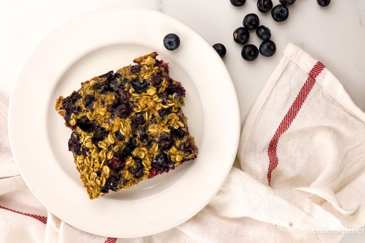 Baked blueberry oatmeal with rolled oats and blueberries on a plate.