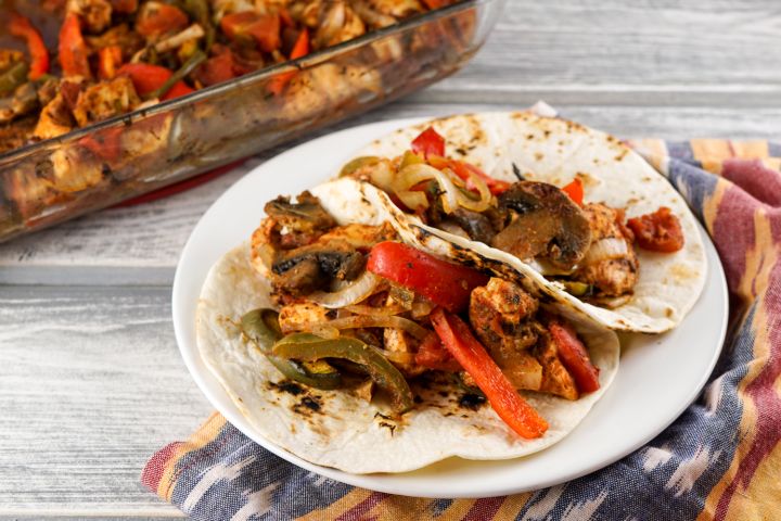 Baked chicken fajitas served in flour tortillas with chicken breast, bell peppers, and red onions. 