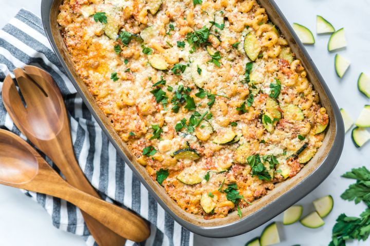 Baked zucchini pasta in a baking dish with melted cheese and zucchini slices.