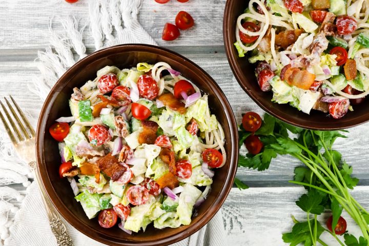 BLT Pasta salad with lettuce, tomatoes, bacon, and spaghetti in a bowl with ranch dressing.