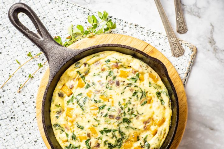Butternut Squash and Spinach Breakfast Casserole in a cast iron skillet with a napkin.