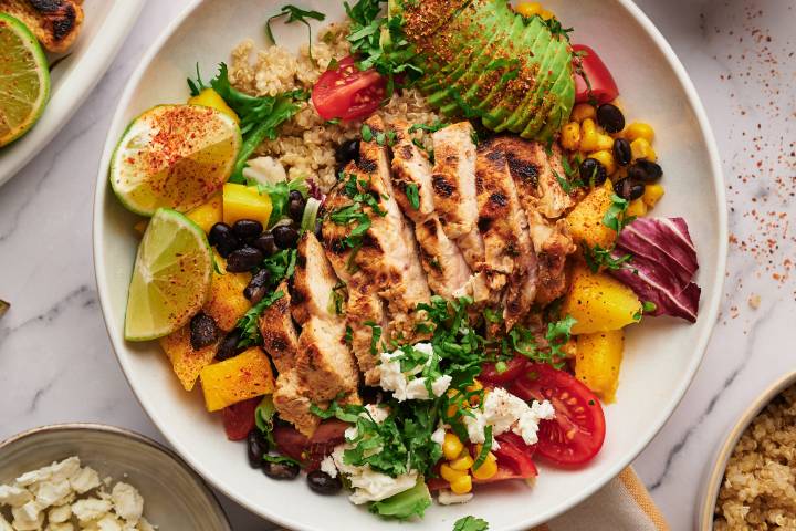 Chicken quinoa bowls with sliced grilled chicken, pico de gallo, cilantro, lime, and chili lime dressing.