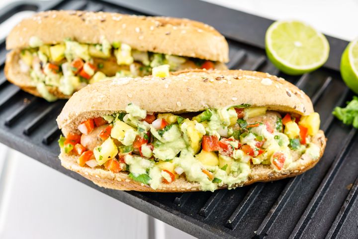 Pineapple chicken sausages in a whole wheat bun with salsa and green sauce.