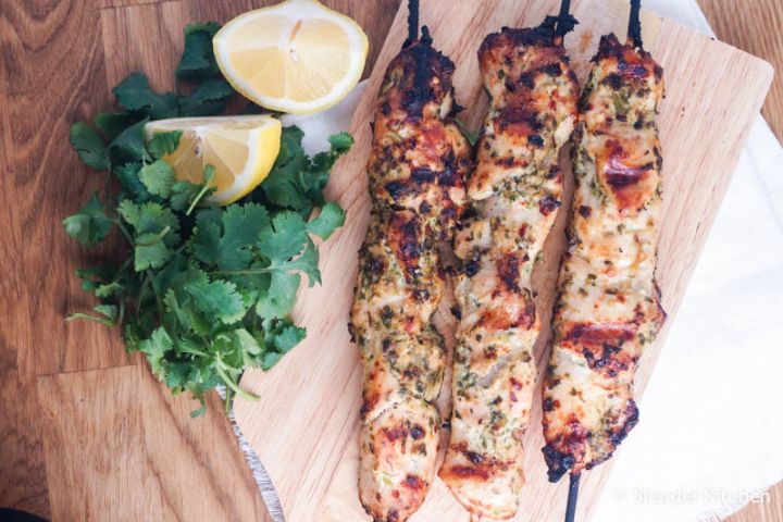 Cilantro pesto chicken skewers served on wooden skewers on a plate.