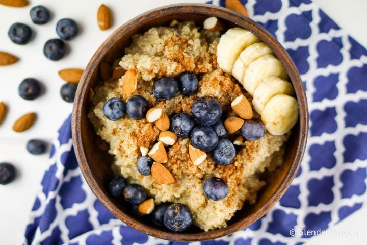 Cinnamon quinoa breakfast bowl  in a wooden bowl with blueberries and almonds.