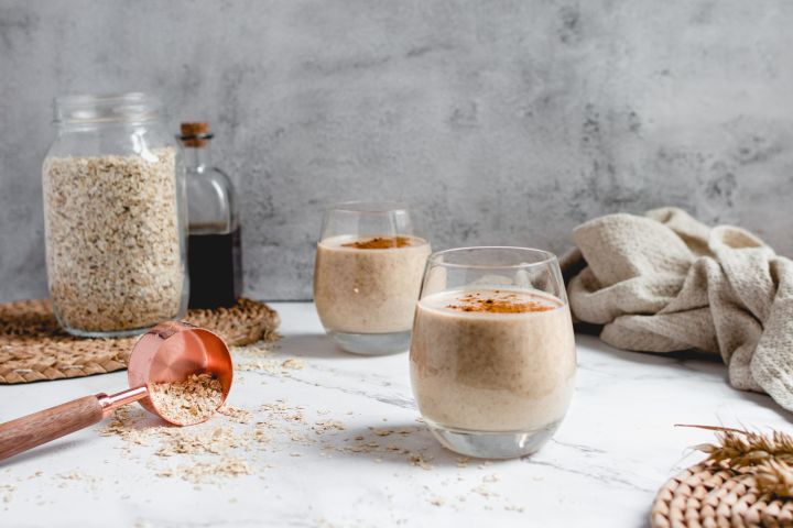 Creamy banana oatmeal smoothie with bananas, oats, almond milk, and almond butter blended and served in two glasses.