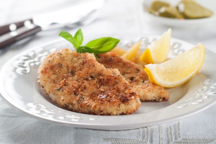 Baked Pork cutlets with a crispy breading on a plate with lemon.