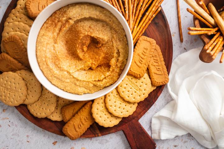 Dessert hummus with chickpeas, cinnamon, maple syrup, almond butter, and dates blended and served with pretzels and graham crackers.