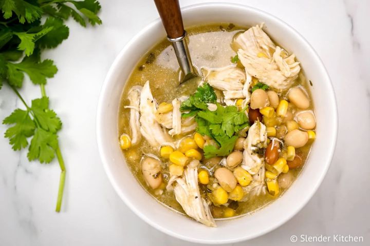 Easy White Chicken Chili with pinto beans, white beans, corn, and chicken in a green salsa broth.