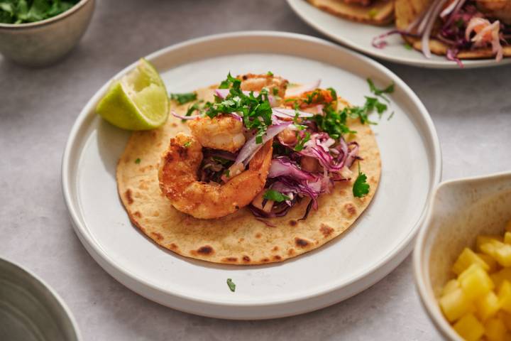 Grilled shrimp tacos with pineapple slaw served on toasted corn tortillas with lime and cilantro.
