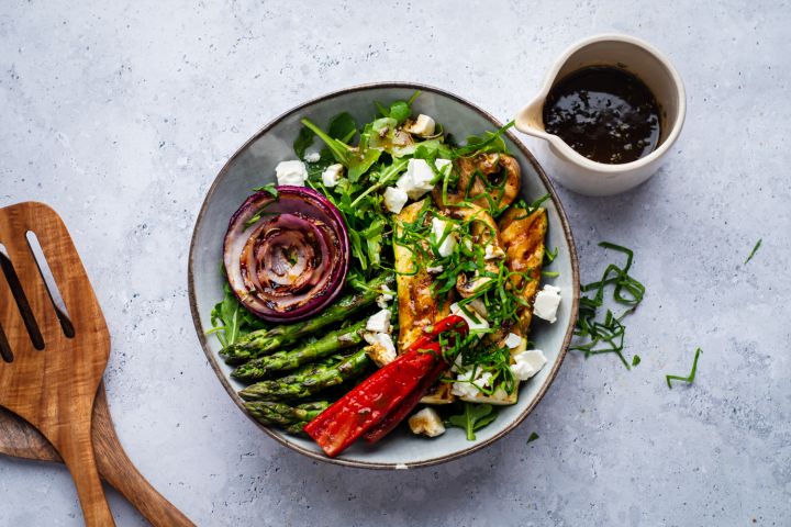 Grilled vegetabe salad with zucchini, asparagus, mushrooms, peppers, onions, and feta cheese served over arugula.