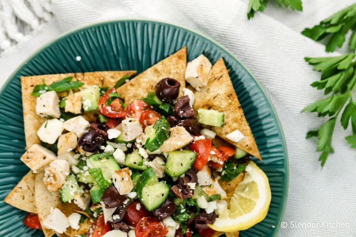 Greek nachos with chicken, cucumbers, tomatoes, red onions, feta cheese, and olives.