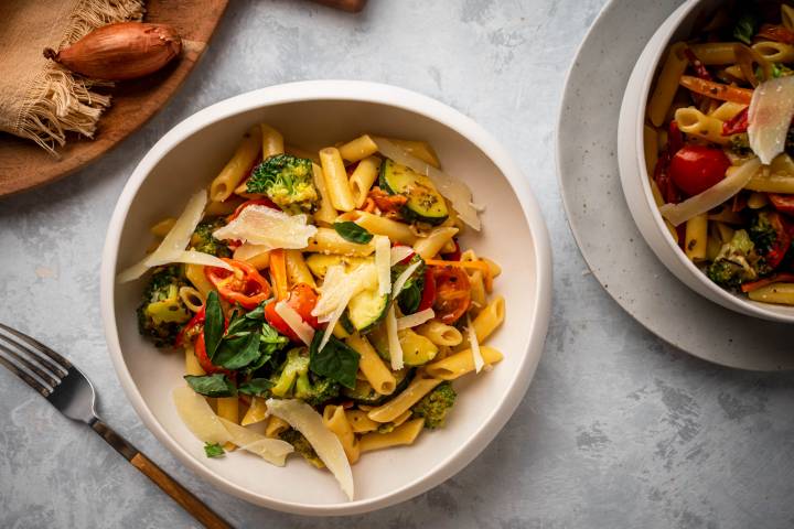 Healthy pasta with broccoli, tomatoes, spinach, zucchini, and whole grain pasta with Parmesan cheese.