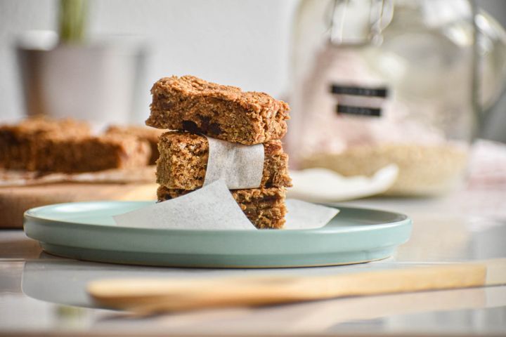 Peanut butter oatmeal bars cut into pieces and served in parchment paper.