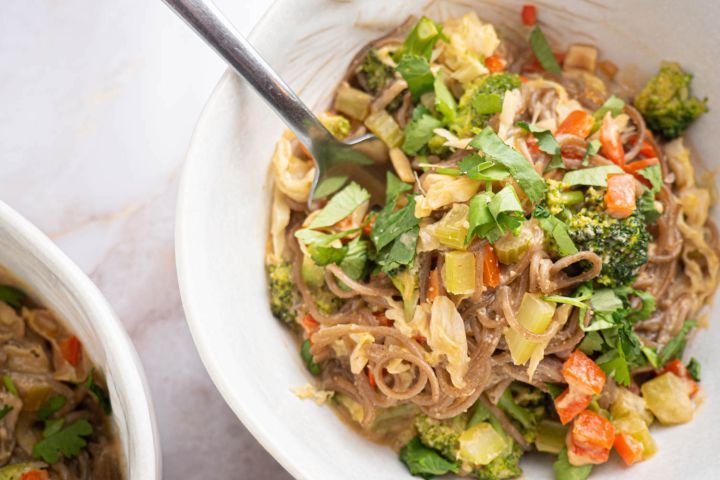 Healthy peanut noodles with broccoli, celery, carrots, and peppers over soba noodles in peanut sauce.