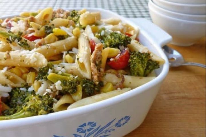 Sausage and Vegetable Pasta with broccoli, corn, and cherry tomatoes in a dish.