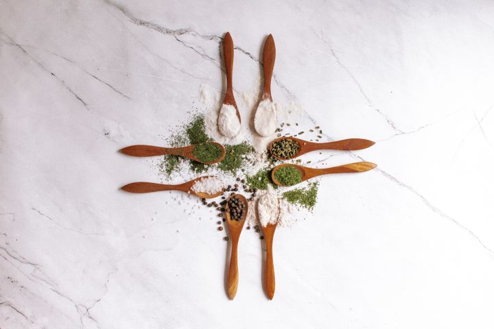 Homemade ranch seasoning in small wooden spoons with dried herbs, buttermilk powder, salt, and pepper.