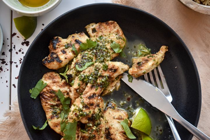 Honey lime chicken with fresh cilantro, honey, lime juice, and red pepper flakes on a plate.