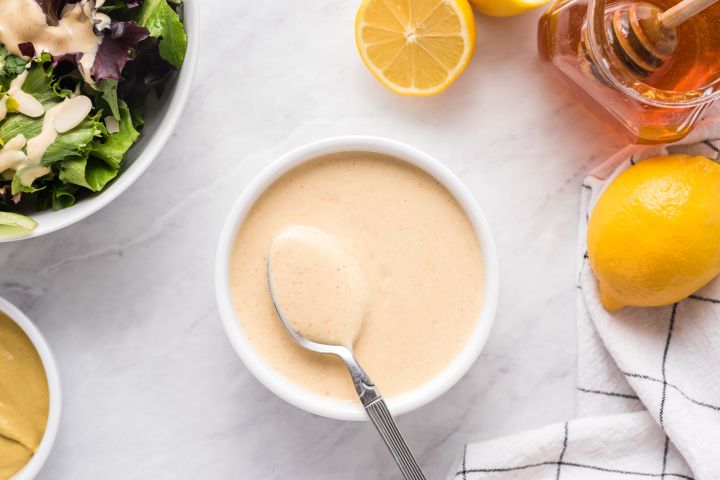 Honey mustard  with Greek yogurt, honey, and Dijon mustard in a small bowl with green salad on the side.