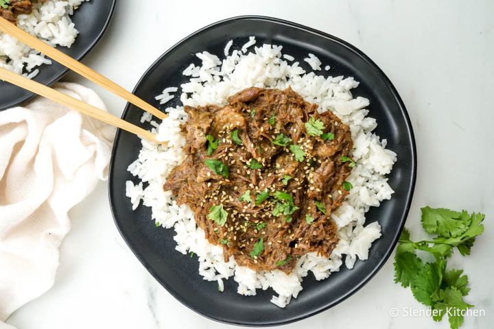 Sesame beef on a bed of white rice with cilantro.