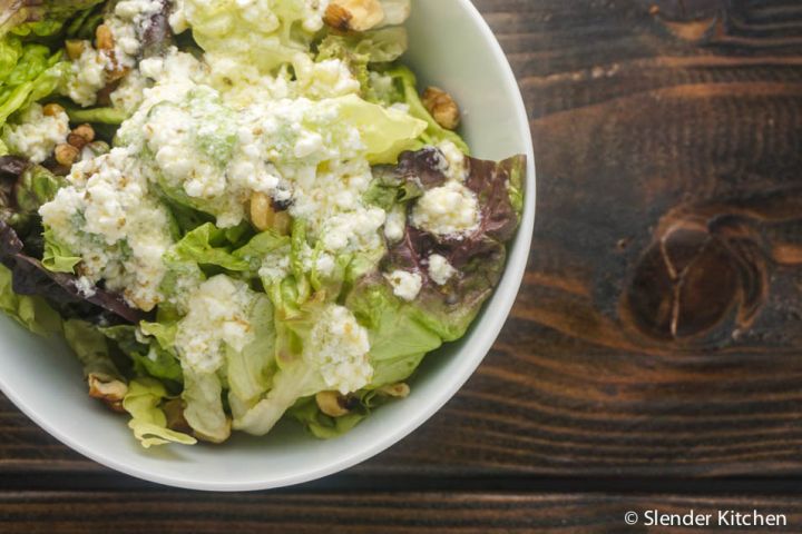 Lemon feta vinaigrette served on a plate of salad greens.