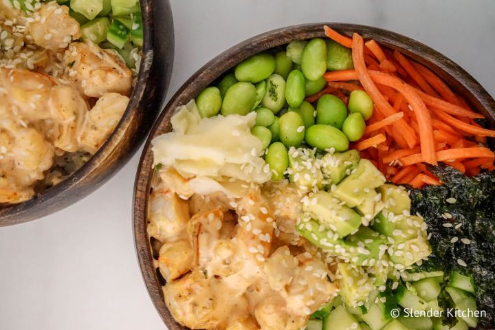 Sushi bowls with shrimp, cauliflower rice, avocado, cucumbers, and carrots.
