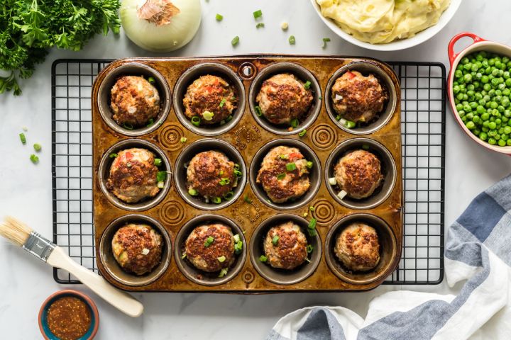 BBQ Meatloaf muffins with ground turkey, red pepper, celery, and a barbecue and mustard sauce in a muffin tin.