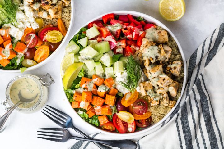 Mediterranean Bowls with chicken, cucumbers, red peppers, feta cheese, sweet potatoes, and tahini dressing.