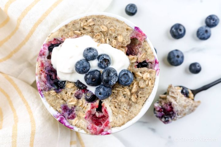 Microwave blueberry muffin in a ramekin with blueberries, yogurt, and walnuts.