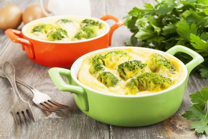 Microwave omelet with broccoli and cheese in a green bowl.