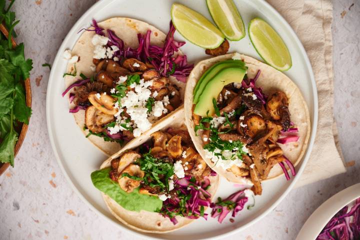 Mushroom tacos with crispy mushrooms, red cabbage slaw, queso fresco, and avocado on corn tortillas.
