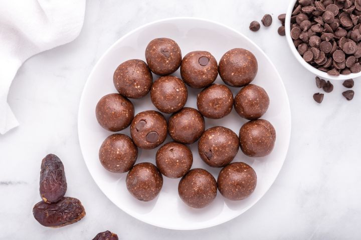 Date Brownie Bites with chocolate chips, Medjool dates, cashews, and almonds on a plate.