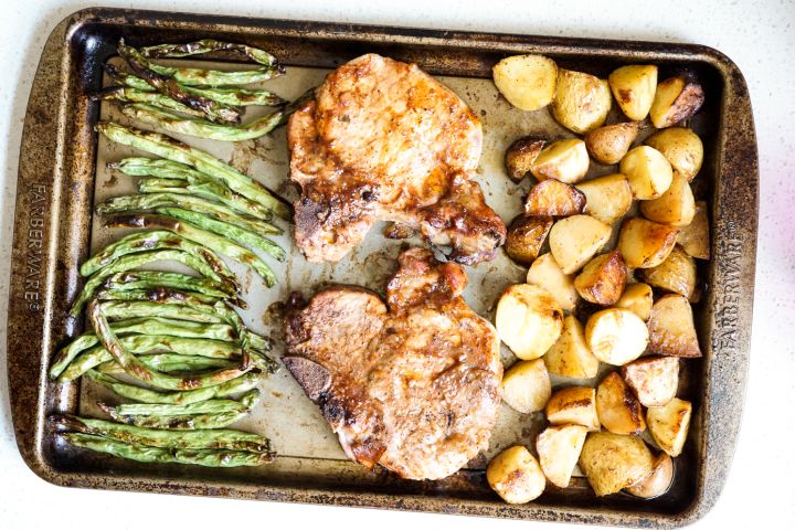 Sheet Pan Pork Chops with potatoes and green beans on a sheet pan.