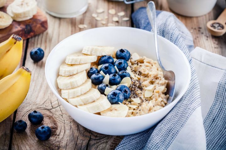 Blueberry chia seed pudding served in a bowl with fresh blueberries and sliced bananas on top.