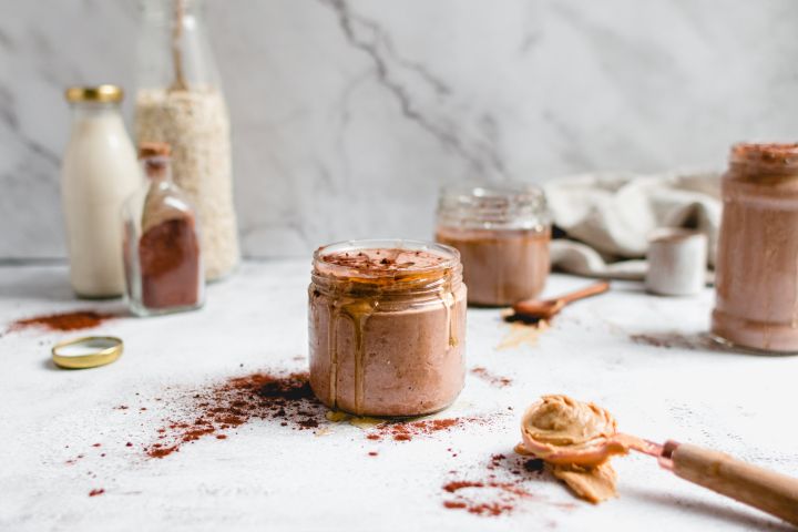 Peanut butter cup smoothie with bananas, oats, peanut butter, and cocoa powder blended and served in a glass.