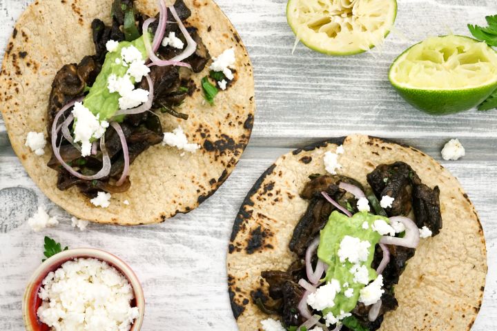 Portobello mushroom tacos with avocado salsa on corn tortillas.