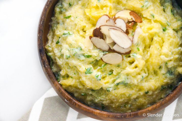 Creamy ricotta spaghetti squash in a wooden bowl with fresh basil on top.