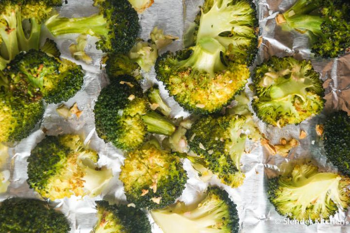 Roasted garlic broccoli with minced garlic on a baking sheet.