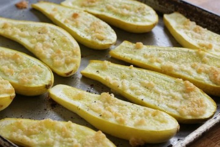 Roasted parmesan summer squash on a baking sheet after being cooked.