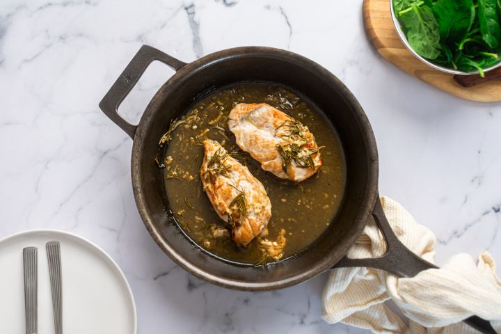 Rosemary chicken with garlic butter in a skillet with pan sauce.