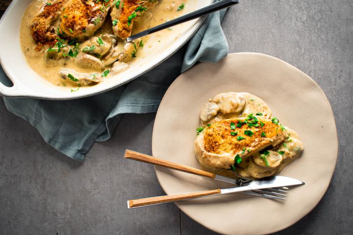 Slow cooker chicken marsala with chicken breast in a mushroom marsala sauce on a plate with parsley.