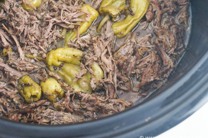 Slow cooker pepperoncini beef in a slow cooker with shredded beef and jarred pepperoncinis.