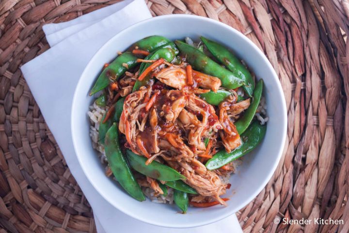 Slow cooker spicy hoisin chicken served in a bowl with carrots and snap peas.