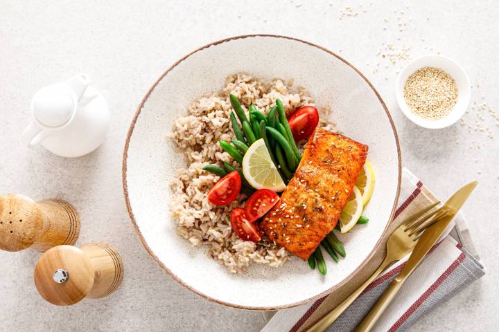 Spicy salmon with chili powder and spices cooked and served with rice and vegetables.