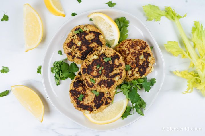 Tuna patties with crispy edges on a plate with fresh lemon and parsley.
